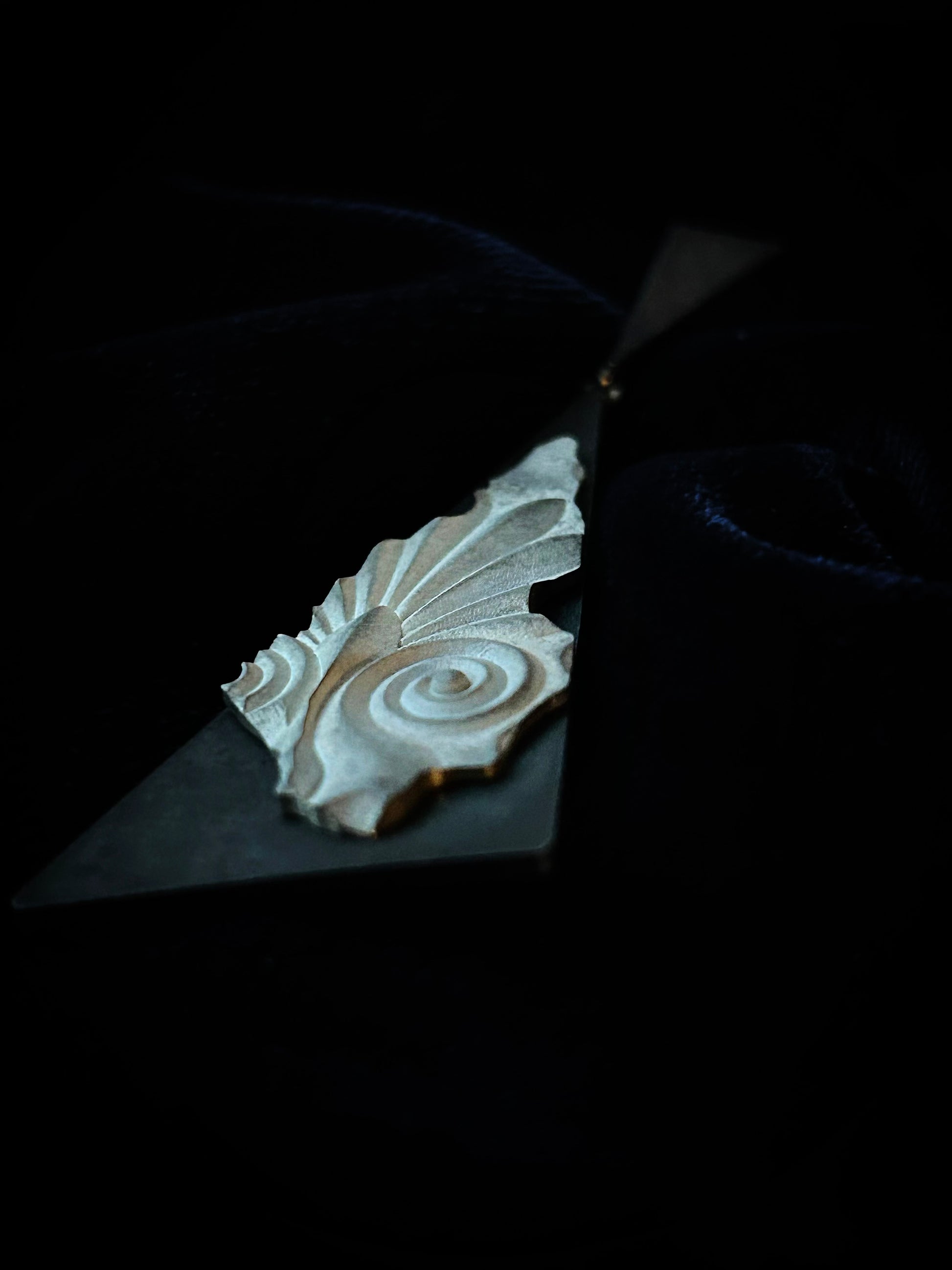 Decorative block with intricate carvings on a dark surface