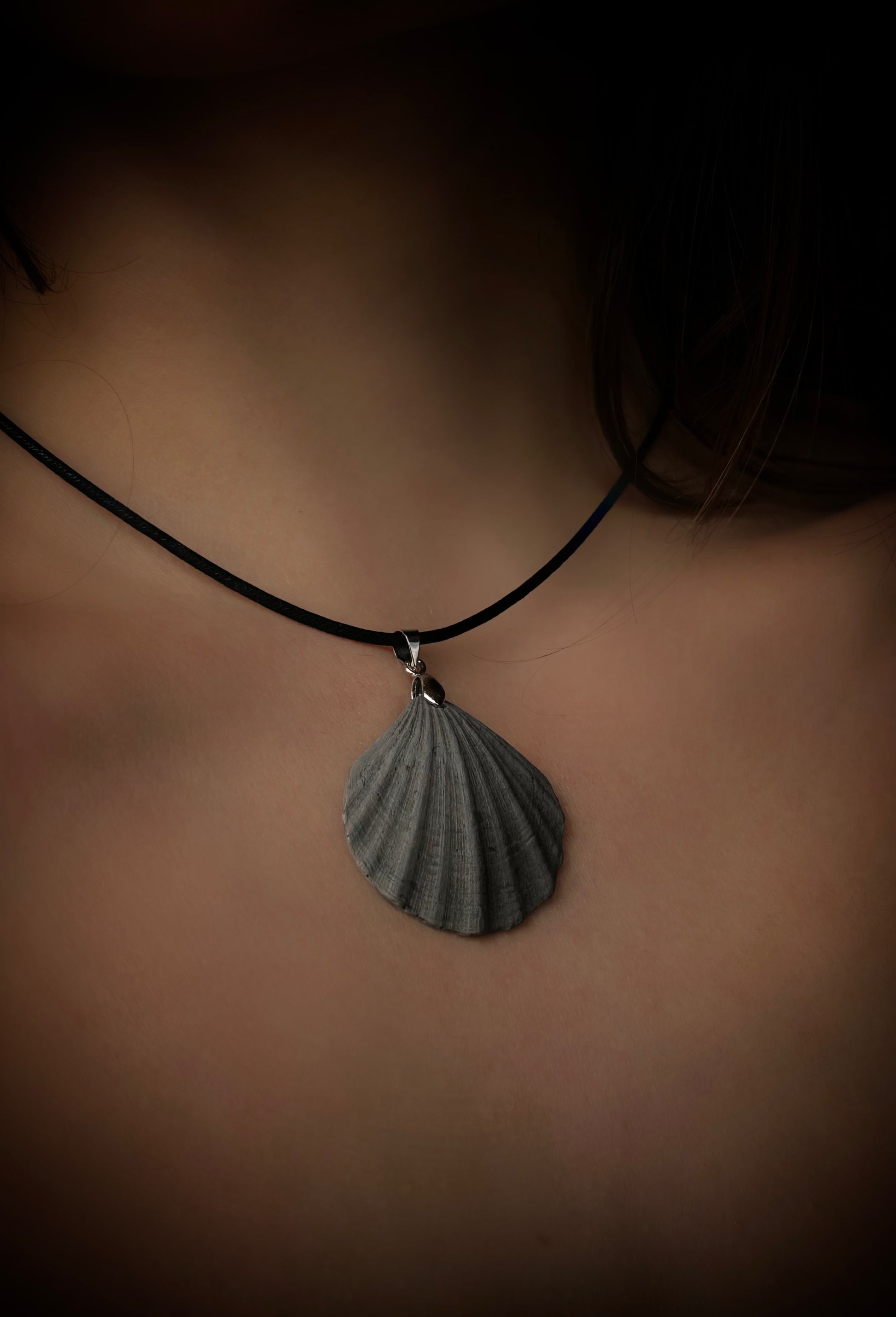 Necklace with a shell pendant on a blurred background