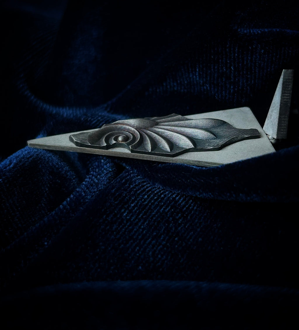 Decorative silver object on a dark blue fabric background